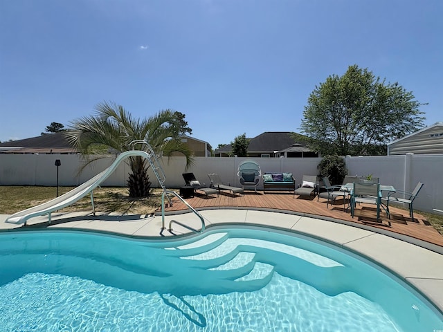 view of swimming pool featuring a fenced backyard, a fenced in pool, a water slide, and a deck