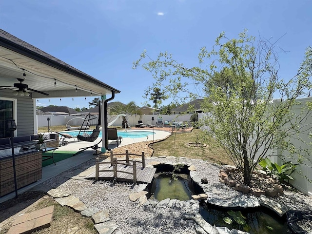 view of swimming pool with ceiling fan, a fenced in pool, a fenced backyard, and a patio area