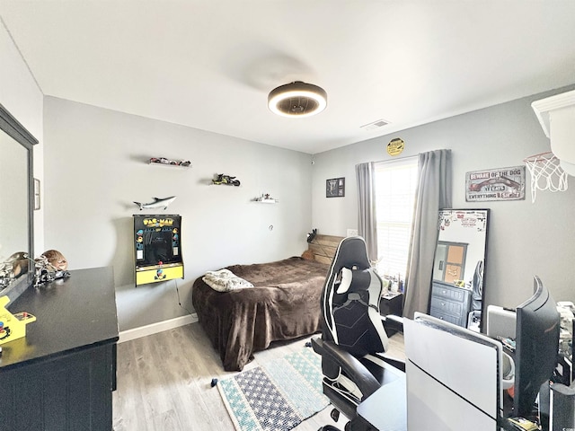 bedroom featuring light wood-style floors, baseboards, and visible vents