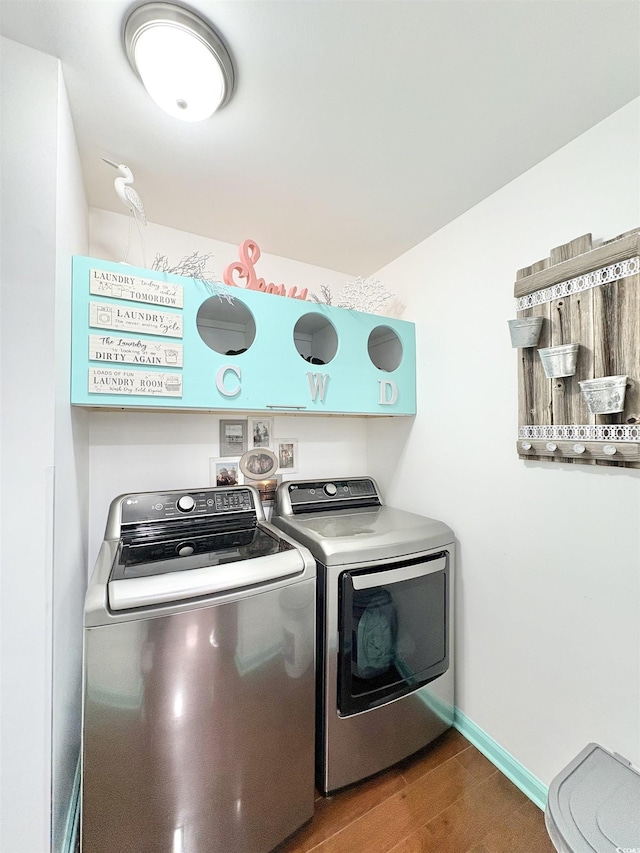laundry room featuring separate washer and dryer, baseboards, laundry area, and wood finished floors