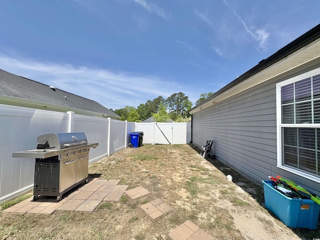 view of patio / terrace featuring a fenced backyard, a gate, and a grill