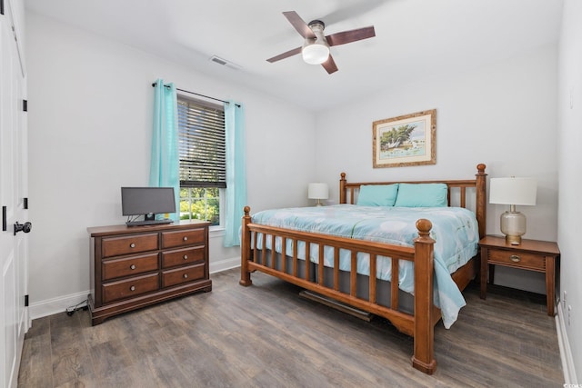 bedroom featuring baseboards, ceiling fan, wood finished floors, and visible vents
