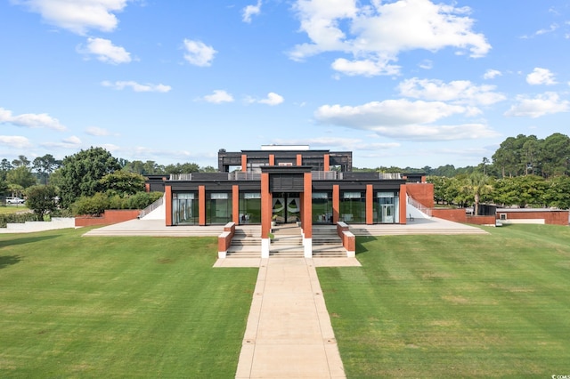 rear view of property featuring a lawn and a patio