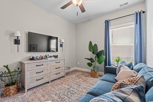 living room with baseboards, ceiling fan, light colored carpet, and visible vents
