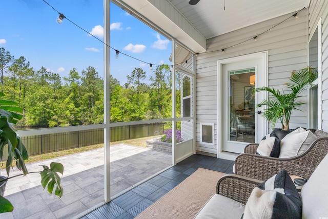 sunroom / solarium featuring ceiling fan