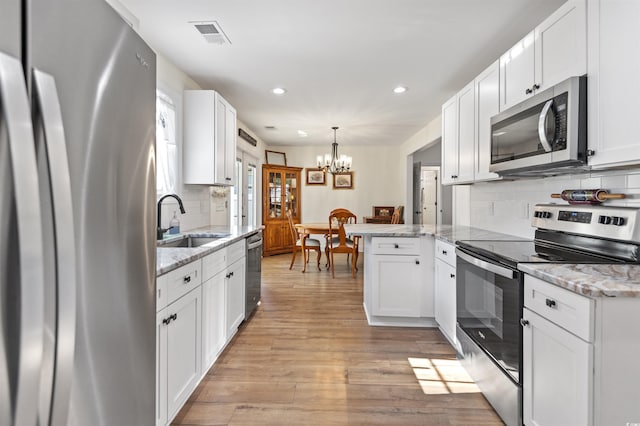 113 Edwards Ln, Longs, SC 29568 - kitchen with stainless steel appliances, a sink, a chandelier, recessed lighting, and white cabinetry