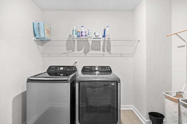 1015 Saltgrass Way, Myrtle Beach, SC 29588 - clothes washing area featuring washing machine and clothes dryer, baseboards, laundry area, and wood finished floors