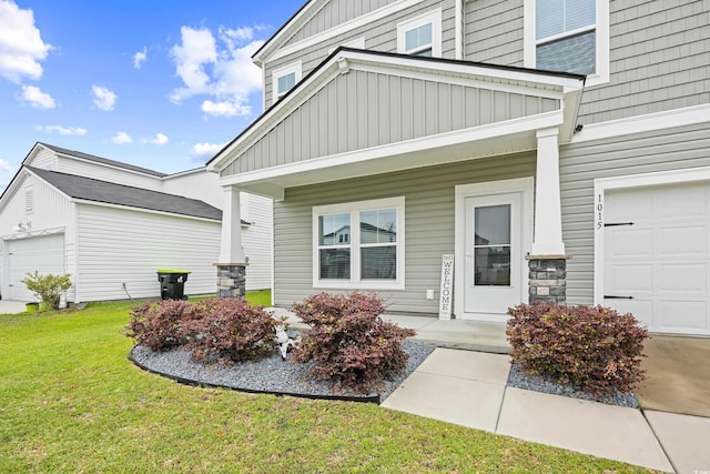 1015 Saltgrass Way, Myrtle Beach, SC 29588 - view of exterior entry featuring a lawn, board and batten siding, a porch, and a garage
