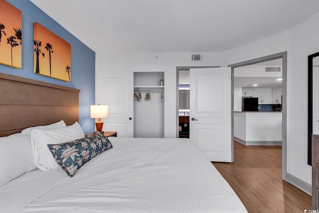 7100 N Ocean Blvd Unit 317, Myrtle Beach, SC 29572 - bedroom featuring freestanding refrigerator, wood finished floors, and a closet