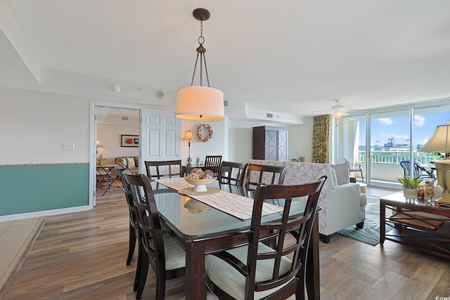 dining space featuring baseboards, ceiling fan, wood finished floors, and visible vents