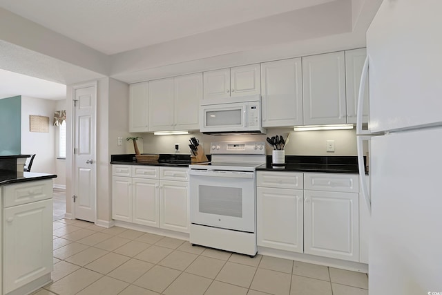 kitchen featuring white appliances, white cabinets, dark countertops, and light tile patterned floors