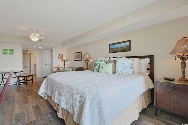 bedroom featuring ceiling fan, visible vents, and wood finished floors