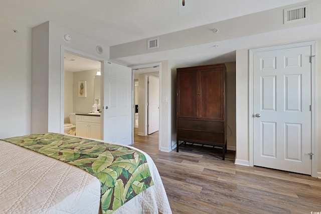 bedroom featuring visible vents, baseboards, and wood finished floors