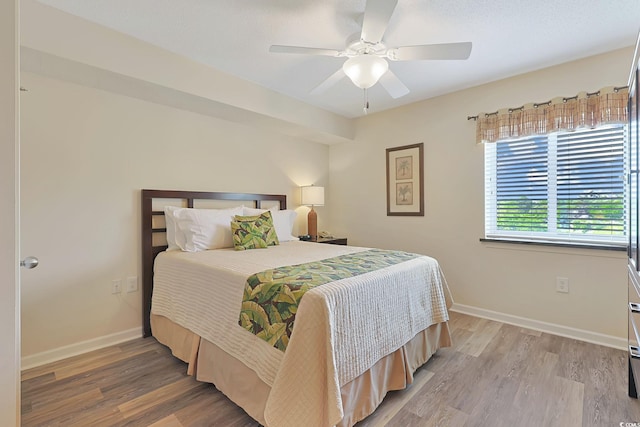 bedroom with baseboards, ceiling fan, and light wood-type flooring