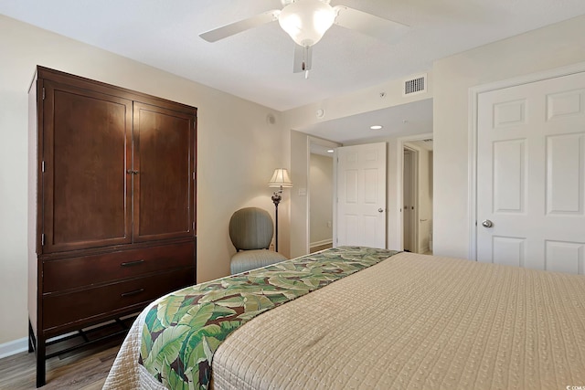 bedroom featuring visible vents, a ceiling fan, baseboards, and wood finished floors