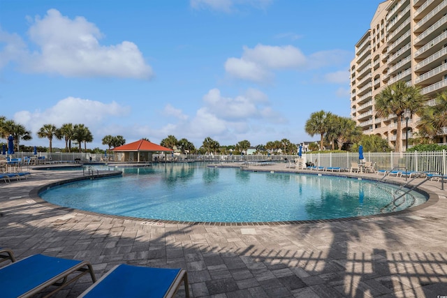 community pool with a patio and fence