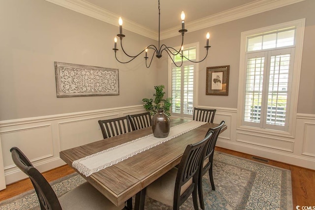 dining room featuring ornamental molding, visible vents, a wealth of natural light, and wood finished floors