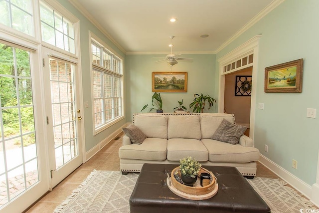 living room with light tile patterned flooring, ceiling fan, ornamental molding, and a wealth of natural light