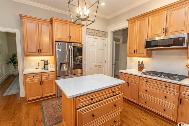 kitchen featuring light countertops, stainless steel appliances, a chandelier, and wood finished floors