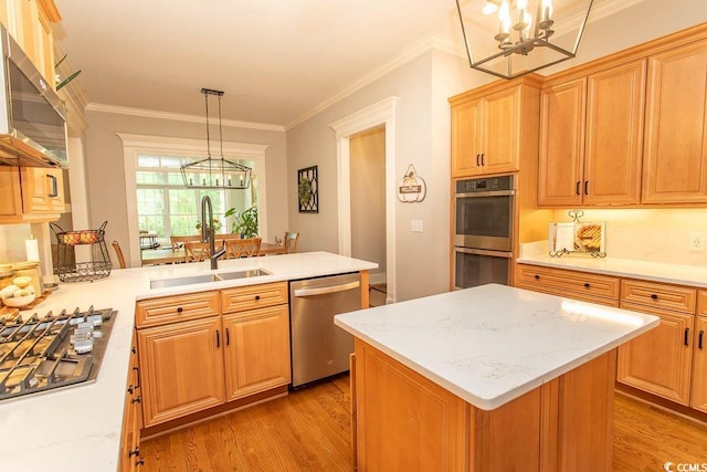 kitchen with appliances with stainless steel finishes, light wood-type flooring, a sink, a peninsula, and an inviting chandelier