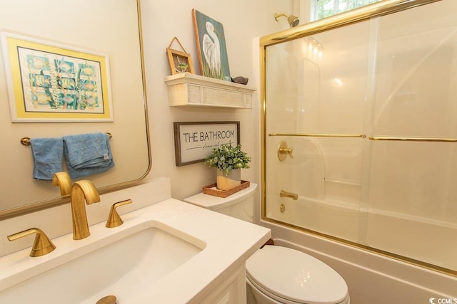 bathroom featuring vanity, toilet, and shower / bath combination with glass door