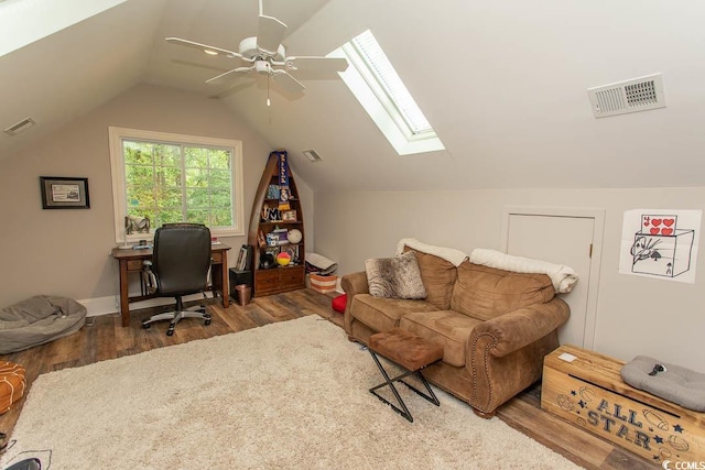 office area featuring visible vents, a ceiling fan, wood finished floors, and vaulted ceiling with skylight
