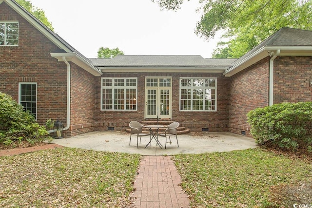 rear view of house featuring brick siding, crawl space, a patio, and roof with shingles