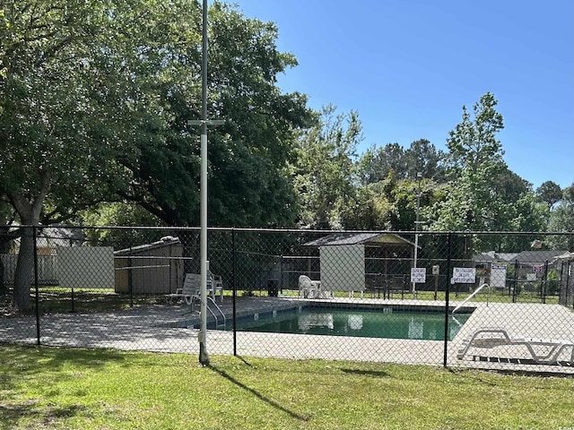 community pool featuring a lawn and fence
