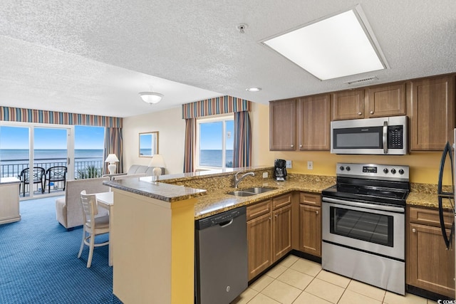 2000 N Ocean Blvd Unit 301, Myrtle Beach, SC 29577 - kitchen featuring stainless steel appliances, a sink, a peninsula, a textured ceiling, and open floor plan