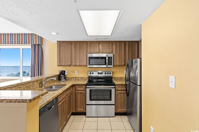 2000 N Ocean Blvd Unit 301, Myrtle Beach, SC 29577 - kitchen with stainless steel appliances, a peninsula, light tile patterned floors, light stone counters, and a sink