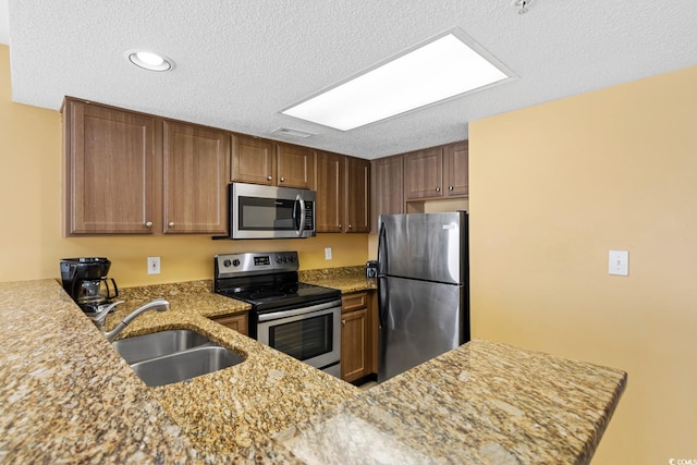2000 N Ocean Blvd Unit 301, Myrtle Beach, SC 29577 - kitchen featuring stainless steel appliances, a sink, light stone counters, a textured ceiling, and recessed lighting