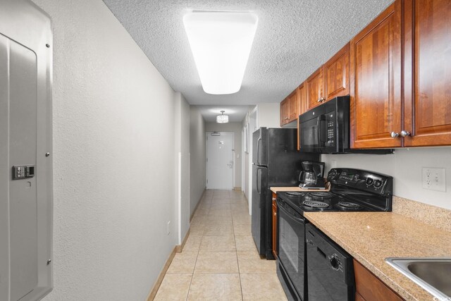 5200 N Ocean Blvd Unit 833, Myrtle Beach, SC 29577 - kitchen with light countertops, a textured ceiling, brown cabinets, light tile patterned floors, and black appliances