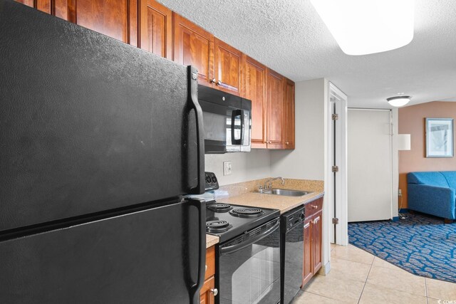 5200 N Ocean Blvd Unit 833, Myrtle Beach, SC 29577 - kitchen featuring brown cabinetry, light countertops, a sink, light tile patterned floors, and black appliances