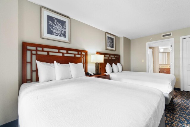 5200 N Ocean Blvd Unit 833, Myrtle Beach, SC 29577 - bedroom featuring visible vents, ensuite bath, and dark colored carpet