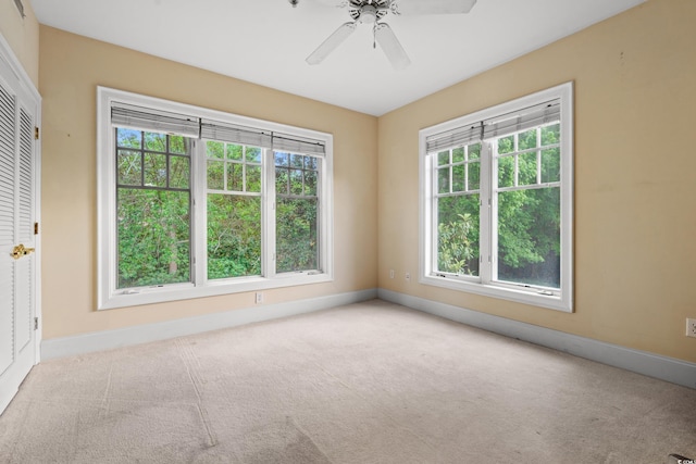 empty room featuring baseboards, a ceiling fan, and carpet