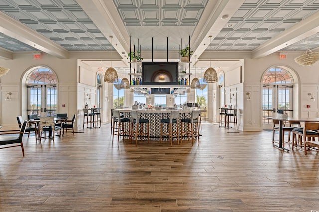 common area with ornamental molding, a towering ceiling, and beamed ceiling