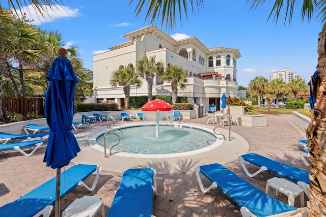 view of swimming pool with a patio and fence