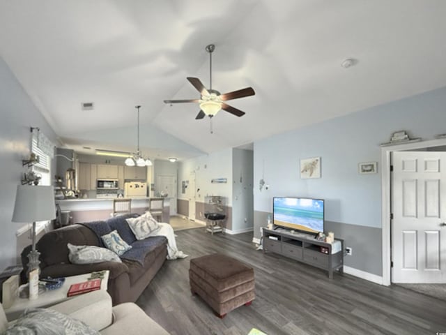 living area with baseboards, dark wood finished floors, ceiling fan with notable chandelier, and lofted ceiling