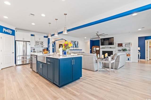 kitchen with a ceiling fan, ornamental molding, recessed lighting, a sink, and stainless steel appliances