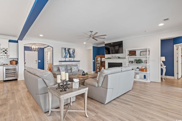 living area with beverage cooler, recessed lighting, ceiling fan with notable chandelier, and a fireplace