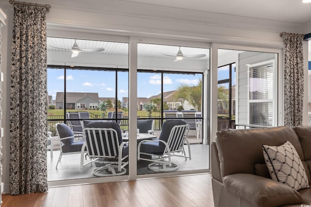 dining area with crown molding, a ceiling fan, wood finished floors, and a residential view