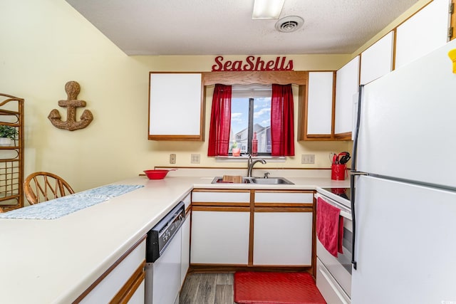 3700 Golf Colony Ln Unit 21B, Little River, SC 29566 - kitchen featuring white appliances, a sink, white cabinetry, wood finished floors, and a textured ceiling