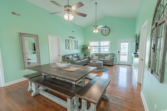 dining room with high vaulted ceiling, ceiling fan, wood finished floors, and baseboards