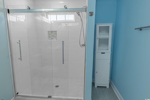 full bathroom featuring a shower stall, baseboards, and tile patterned floors