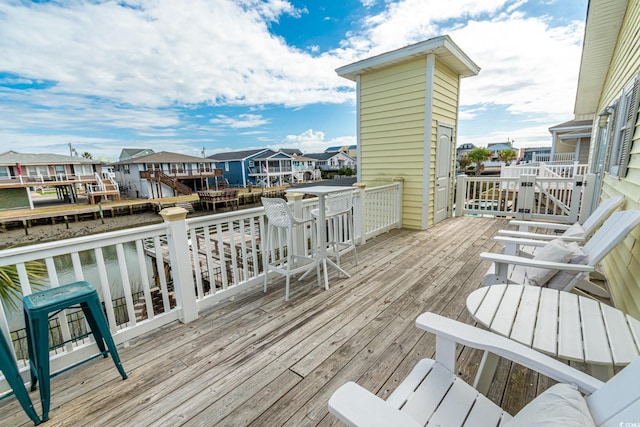 wooden terrace featuring a water view and a residential view