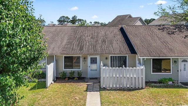 view of front of property with a front yard and a shingled roof