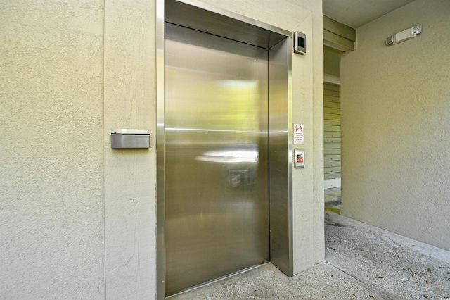 view of exterior entry with elevator and stucco siding