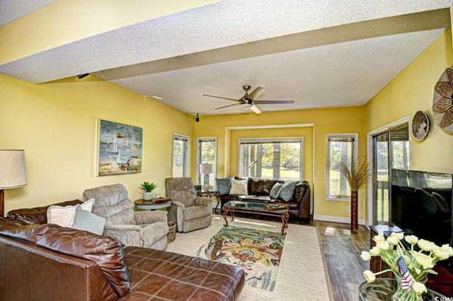 living area with baseboards, dark wood-style flooring, and ceiling fan