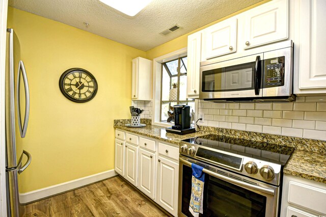 1401 Lighthouse Dr Unit 4226, North Myrtle Beach, SC 29582 - kitchen with appliances with stainless steel finishes, baseboards, wood finished floors, tasteful backsplash, and visible vents