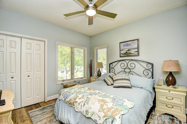 bedroom featuring a closet, a ceiling fan, baseboards, and wood finished floors